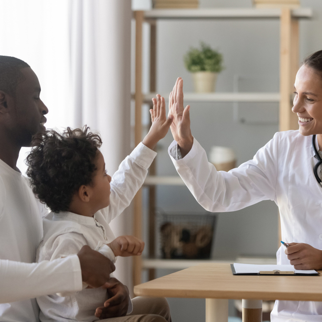 a doctor high-fiving a small child